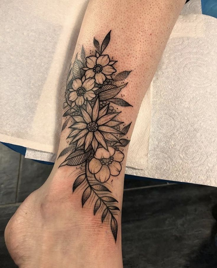 Hình xăm hoa phong cách blackwork trên chân, chi tiết sắc nét, ảnh HD.