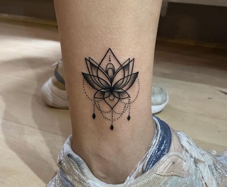 Hình xăm hoa sen, vị trí cổ chân, phong cách blackwork, chi tiết rõ nét, độ phân giải HD.