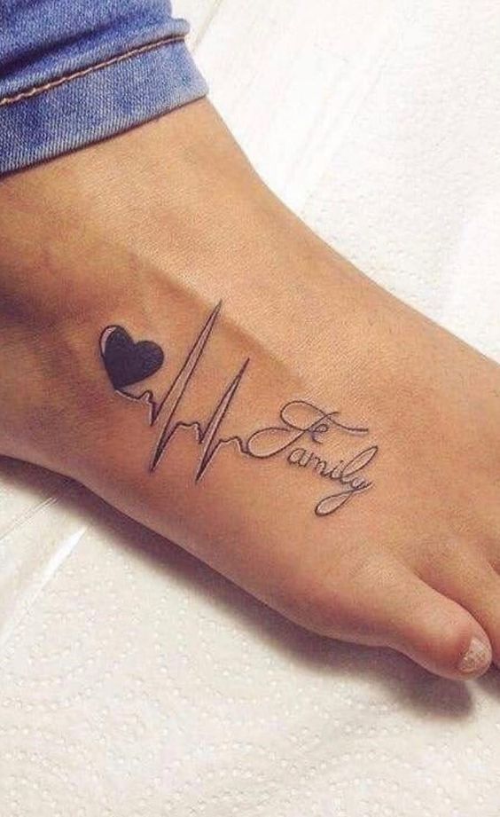 Hình xăm nhịp tim và chữ "Family" trên bàn chân, phong cách blackwork, độ chi tiết cao.