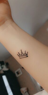 Hình xăm vương miện mini trên cổ tay, phong cách blackwork, ảnh độ phân giải HD.
