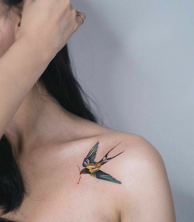 Hình xăm chim én trên vai, phong cách màu nước, chi tiết sắc nét, ảnh độ phân giải cao.