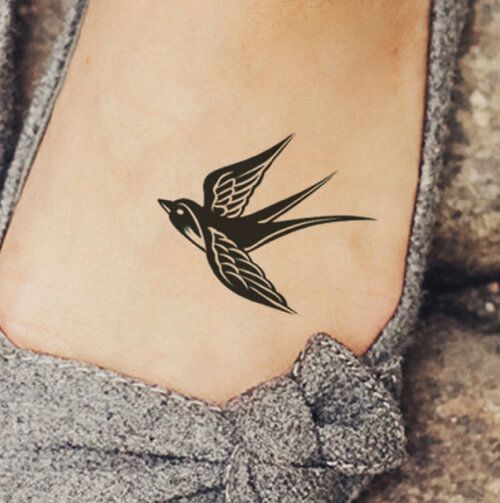 Hình xăm chim én blackwork trên bàn chân, phong cách tối giản, ảnh HD rõ nét.