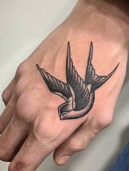 Hình xăm chim én trên mu bàn tay, phong cách blackwork, chi tiết rõ nét, ảnh độ phân giải HD.