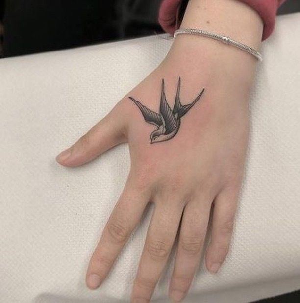 Hình xăm chim én trên bàn tay, phong cách blackwork, chi tiết rõ nét, ảnh HD.