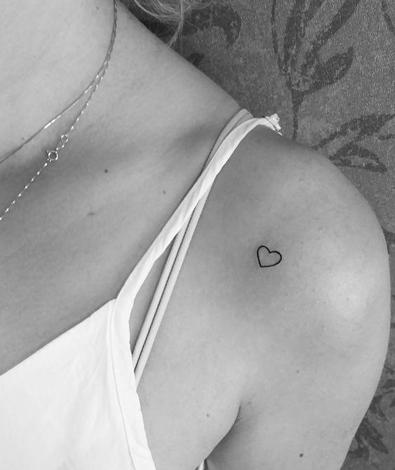 mẫu xăm trái tim đơn giản cho nữ ở vai Hình xăm trái tim nhỏ trên vai, phong cách blackwork, chi tiết tối giản, ảnh đen trắng, độ phân giải HD.