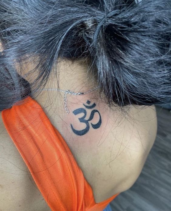 mẫu xăm chữ om mini sau gáy Hình xăm ký tự Om phong cách blackwork ở gáy, chi tiết rõ nét, ảnh HD.