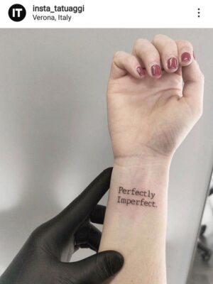 Hình xăm chữ "Perfectly Imperfect" trên cổ tay, phong cách tối giản, ảnh HD.