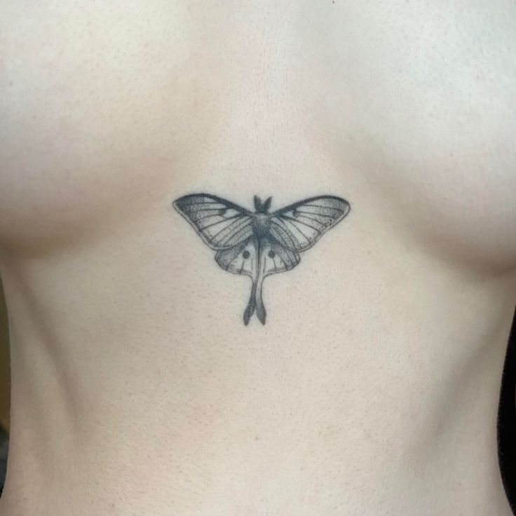 Hình xăm bướm tối giản trên ngực, phong cách blackwork, chi tiết rõ nét, độ phân giải HD.