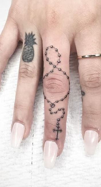 mẫu xăm công giáo mini ở ngón tay cho nữ Hình xăm chuỗi tràng hạt và dứa trên ngón tay, phong cách blackwork, chi tiết, ảnh HD.