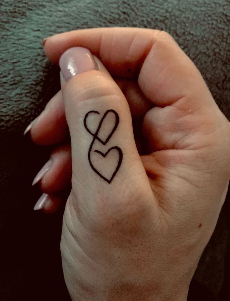 thiết kế xăm hai hình trái tim đậm ở ngón cái Hình xăm mini hai trái tim trên ngón tay, phong cách blackwork, chi tiết đơn giản, ảnh HD.