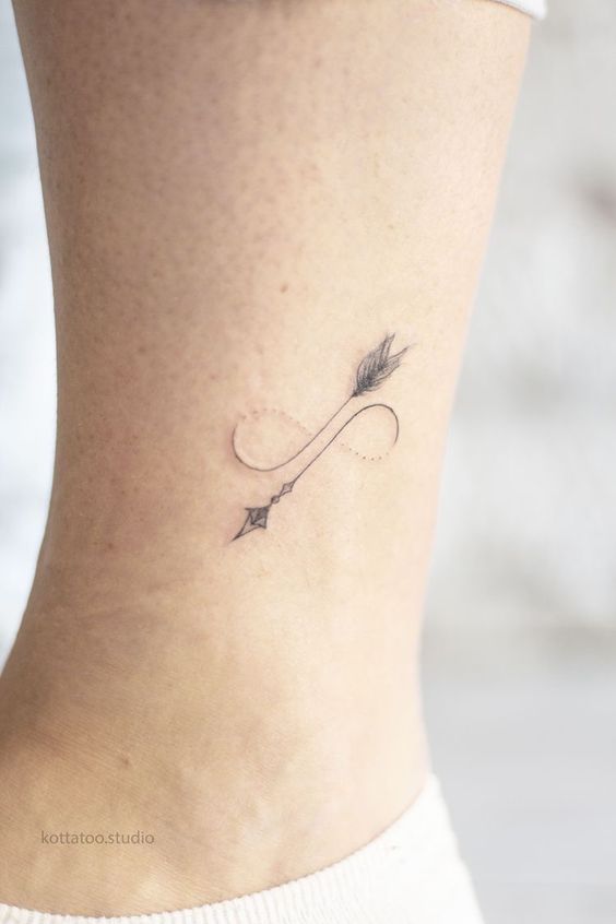 Hình xăm mũi tên vô cực mini ở eo, phong cách blackwork, chi tiết tinh tế, ảnh HD.