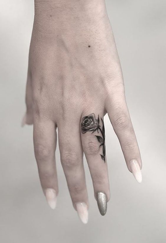 Hình xăm hoa mini trên ngón tay, phong cách blackwork, chi tiết rõ, ảnh độ phân giải HD.