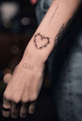 Hình xăm trái tim gai trên cánh tay, phong cách blackwork, chi tiết cao, ảnh HD.