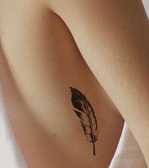 Hình xăm lông vũ ở bên sườn, phong cách blackwork, chi tiết tinh tế, ảnh chất lượng HD.