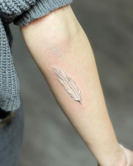 Hình xăm lông vũ mini trên tay, phong cách tối giản, độ phân giải HD.