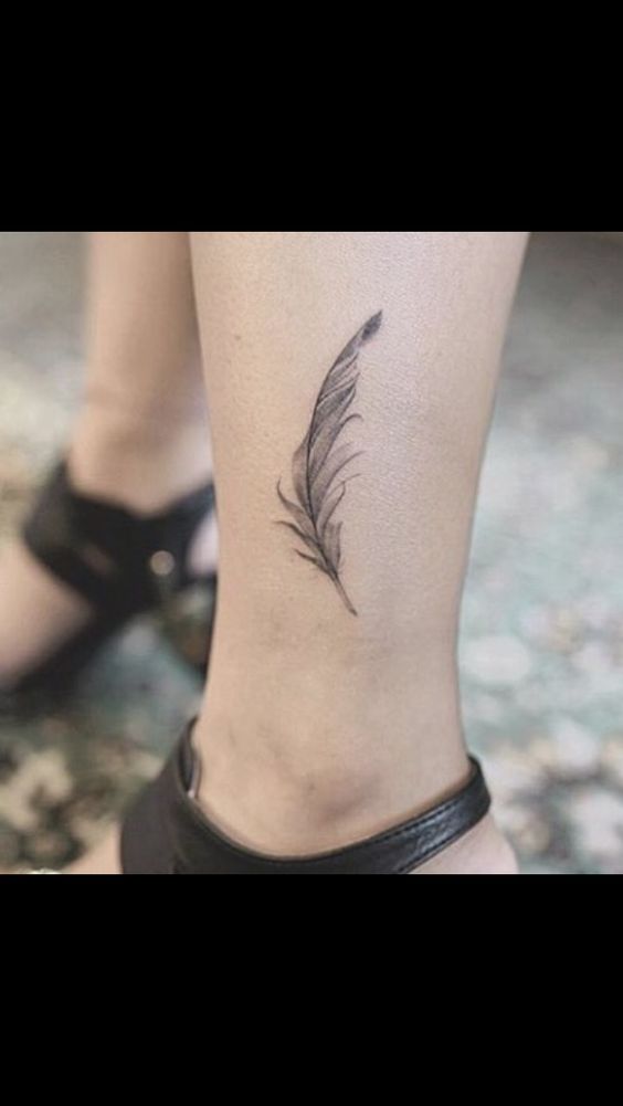 Hình xăm lông vũ mini trên mắt cá chân, phong cách blackwork, ảnh HD chi tiết.