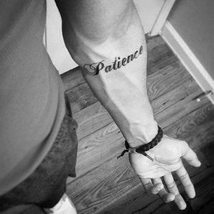 Hình xăm chữ "Patience" trên cánh tay, phong cách blackwork, ảnh đen trắng, độ phân giải HD.