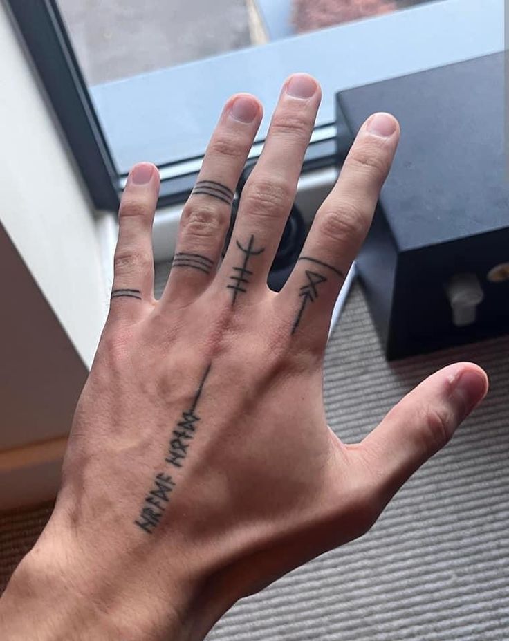 nét đẹp nam tính với mẫu xăm ngón tay Hình xăm ký hiệu trên ngón tay, phong cách blackwork, chi tiết tối giản, ảnh HD.