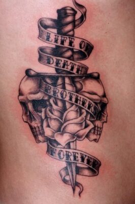 Hình xăm hai đầu lâu và băng rôn trên bắp tay, phong cách blackwork, độ chi tiết cao, ảnh HD.