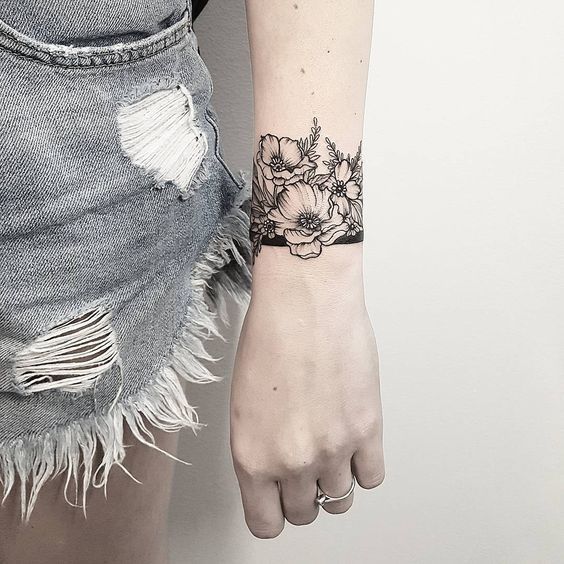Hình xăm hoa đen trắng trên cổ tay, phong cách blackwork, chi tiết tinh xảo, ảnh độ phân giải HD.