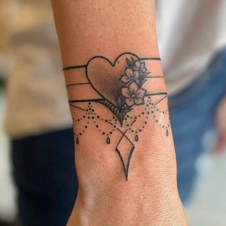 Hình xăm trái tim và hoa trên cổ tay, phong cách blackwork, chi tiết rõ nét, ảnh HD.