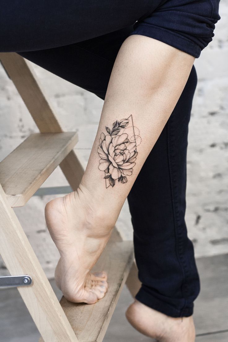 Hình xăm hoa trên cẳng chân, phong cách blackwork, chi tiết rõ nét, ảnh HD.