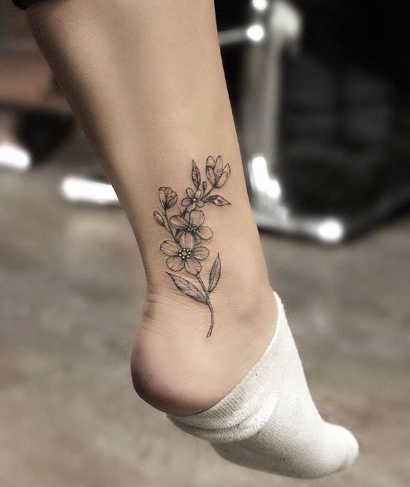 Hình xăm hoa phong cách blackwork ở mắt cá chân, chi tiết rõ nét, ảnh HD.