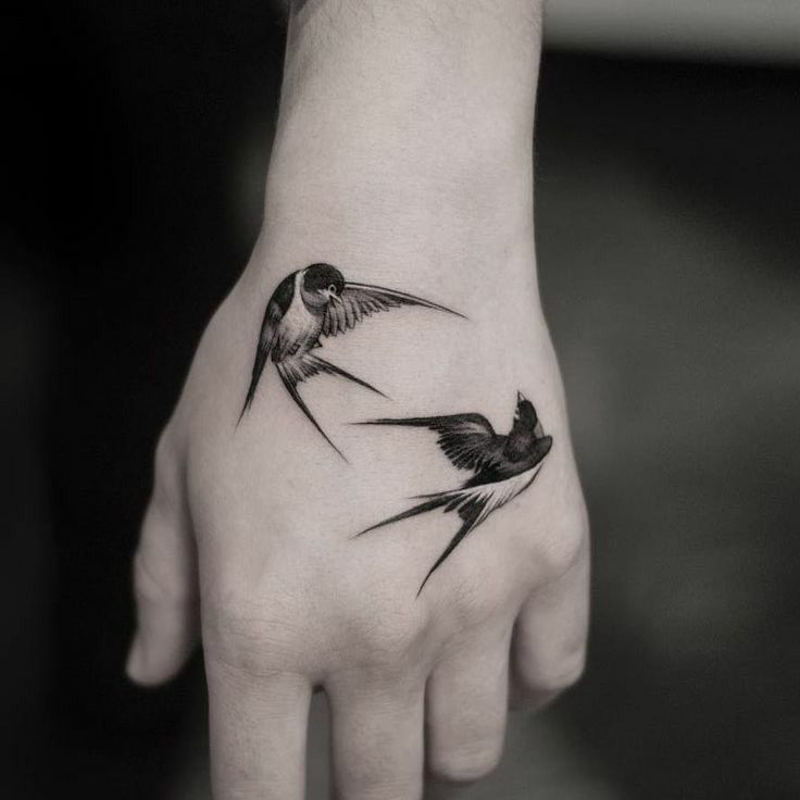 Hình xăm chim én trên mu bàn tay, phong cách blackwork, chi tiết rõ nét, ảnh HD.
