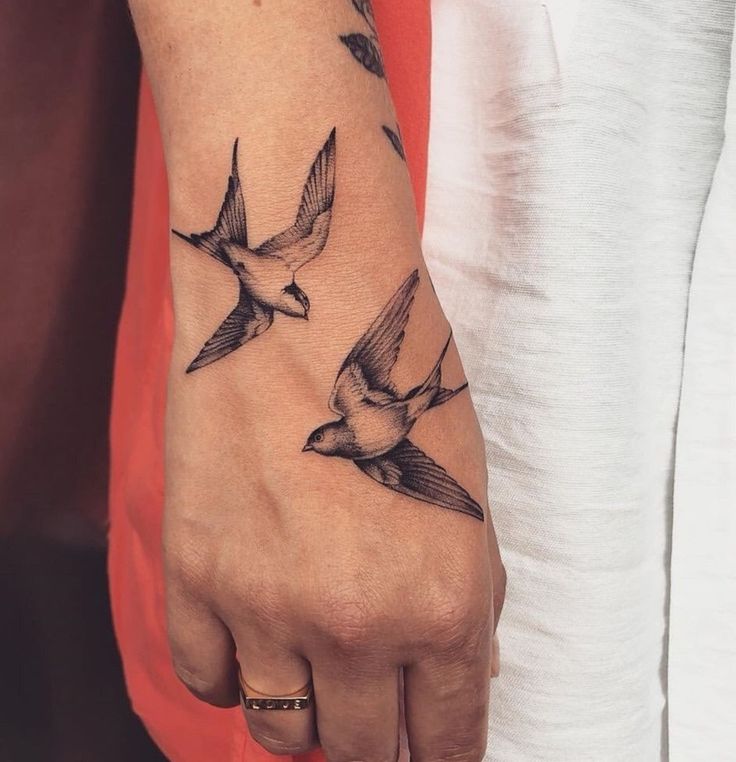 Hình xăm chim cổ điển trên tay, phong cách blackwork, chi tiết sắc nét, độ phân giải HD.