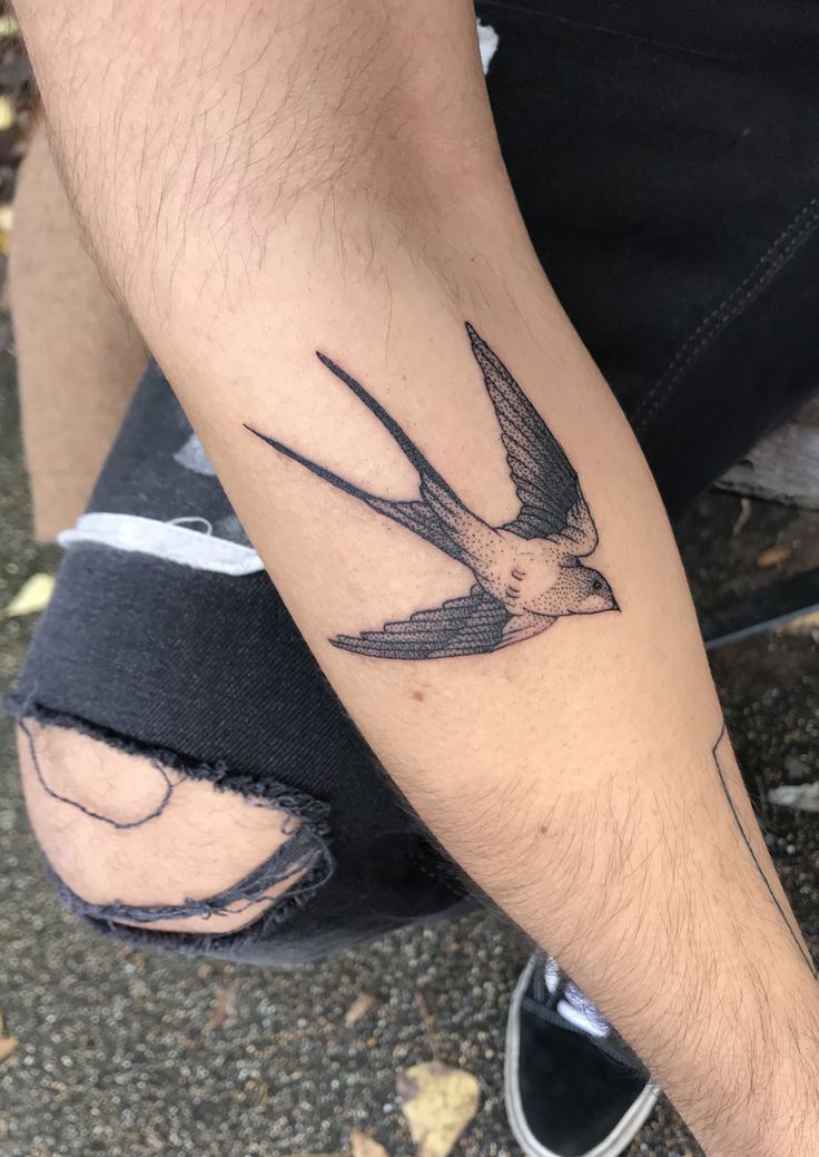 Hình xăm chim én trên tay, phong cách blackwork, chi tiết sắc nét, độ phân giải HD.