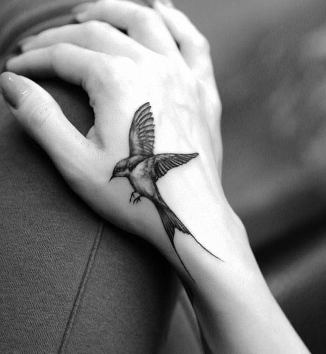 Hình xăm chim trên mu bàn tay, phong cách blackwork, chi tiết rõ nét, ảnh đen trắng.
