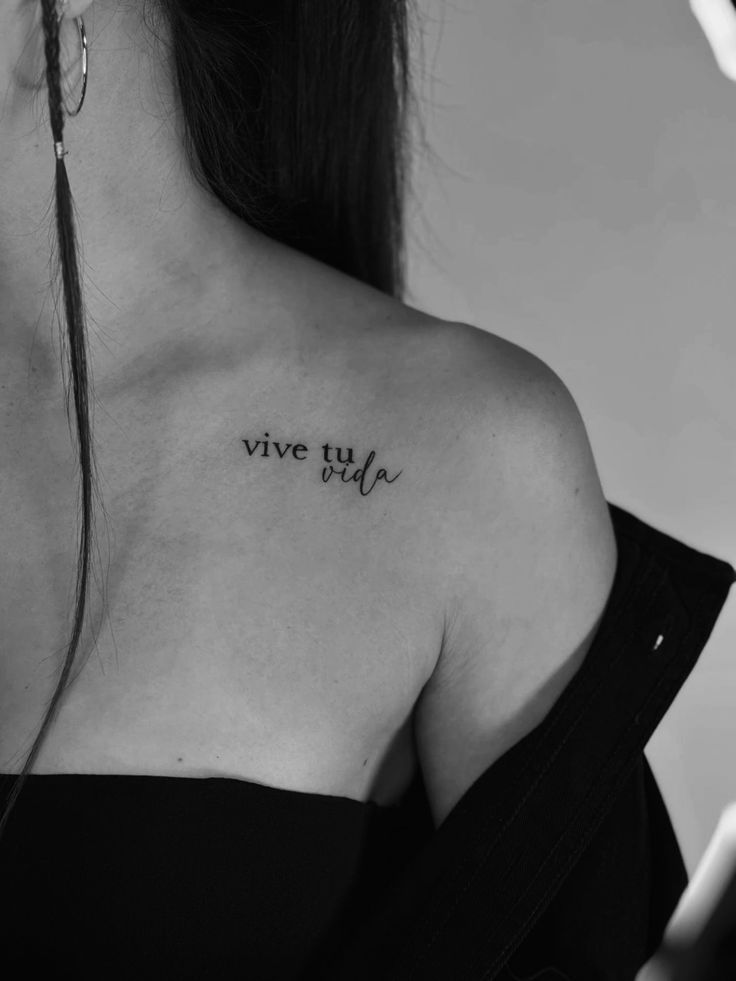 Hình xăm chữ "vive tu vida" trên vai, phong cách chữ mảnh, ảnh đen trắng, chi tiết rõ nét, độ phân giải HD.