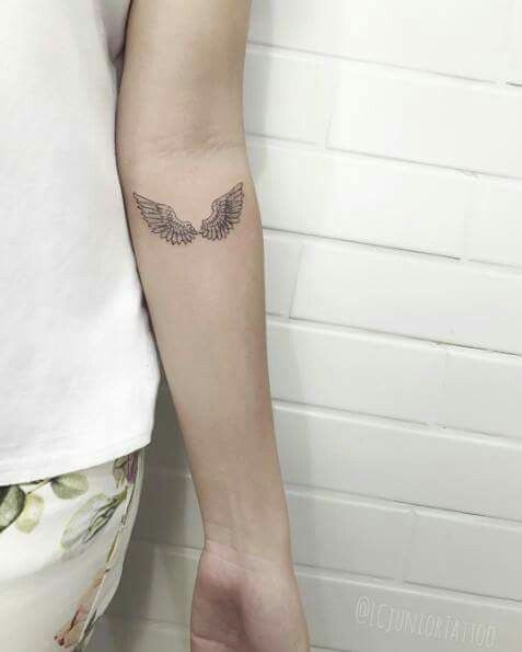 Hình xăm đôi cánh nhỏ ở tay, phong cách blackwork, chi tiết rõ nét, ảnh độ phân giải HD.