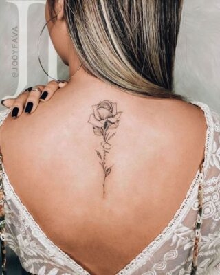 Hình xăm hoa hồng trên lưng, phong cách blackwork tinh tế, ảnh độ phân giải cao.