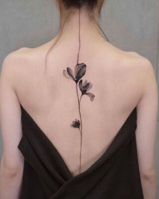 Hình xăm hoa phong cách blackwork dọc sống lưng, chi tiết tinh tế, ảnh HD.