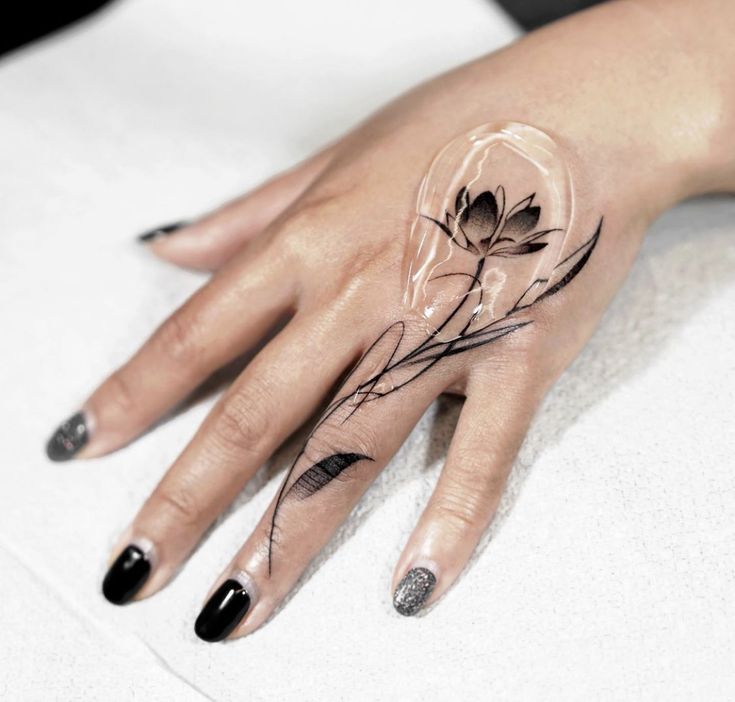 hình xăm hoa sen ở ngón áp út Hình xăm hoa sen trên tay, phong cách blackwork tinh tế, ảnh HD chi tiết.