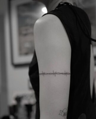 Hình xăm vòng dây kẽm gai trên bắp tay, phong cách blackwork, chi tiết, ảnh đen trắng, độ phân giải HD.