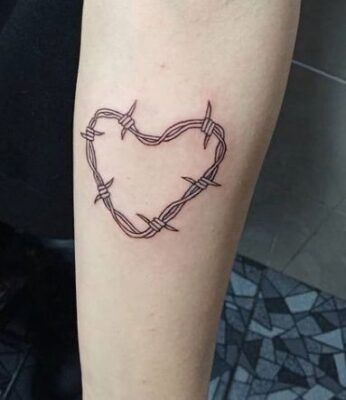 Hình xăm trái tim dây thép gai ở tay, phong cách blackwork, chi tiết rõ nét, ảnh độ phân giải HD.