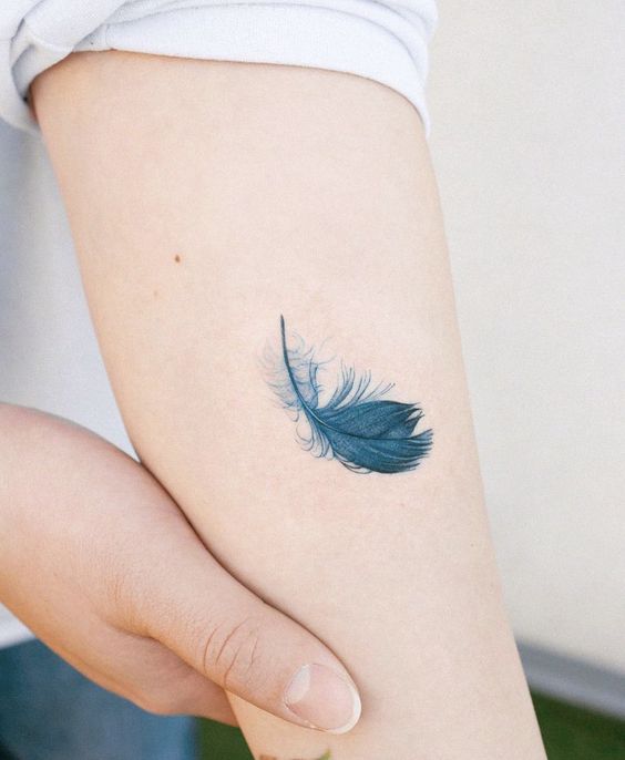 Hình xăm lông vũ mini trên tay, phong cách màu nước tinh tế, độ phân giải HD.
