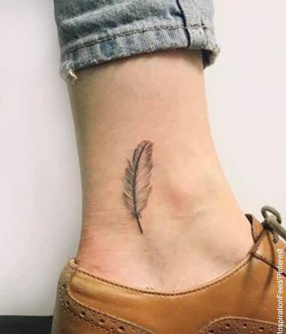 Hình xăm lông vũ mini ở mắt cá chân, phong cách blackwork, chi tiết tinh tế, ảnh HD.