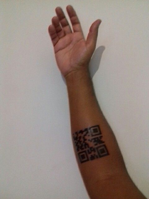 Hình xăm QR code trên cẳng tay, phong cách blackwork, ảnh độ phân giải trung bình.