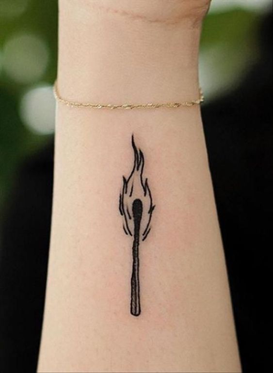Hình xăm que diêm cháy trên cổ tay, phong cách blackwork, chi tiết đơn giản, ảnh HD.
