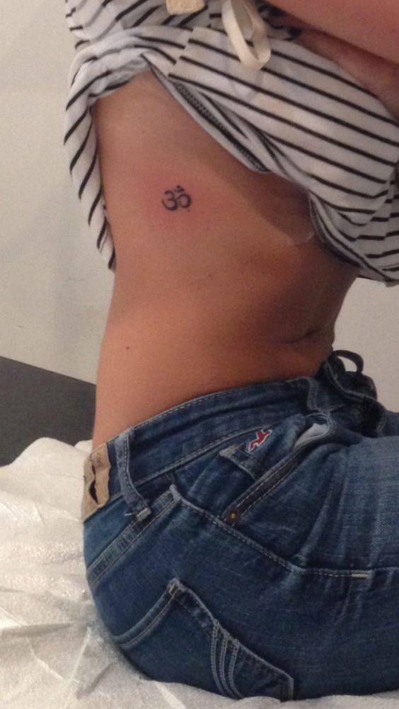 tattoo mini chữ om xinh ở ngực Hình xăm ký hiệu Om trên hông, phong cách tối giản, độ phân giải HD.