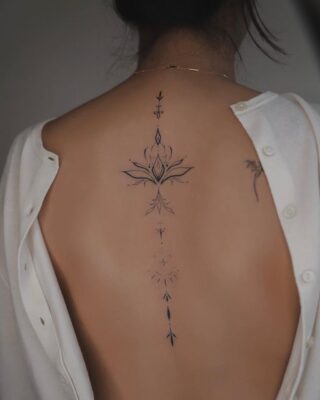 Hình xăm hoa sen tinh tế trên lưng, phong cách blackwork, chi tiết sắc nét, ảnh HD.