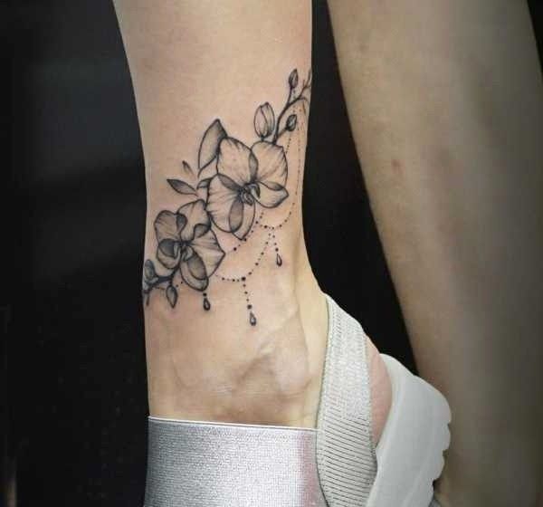 Hình xăm hoa trên mắt cá chân, phong cách blackwork chi tiết, độ phân giải HD.