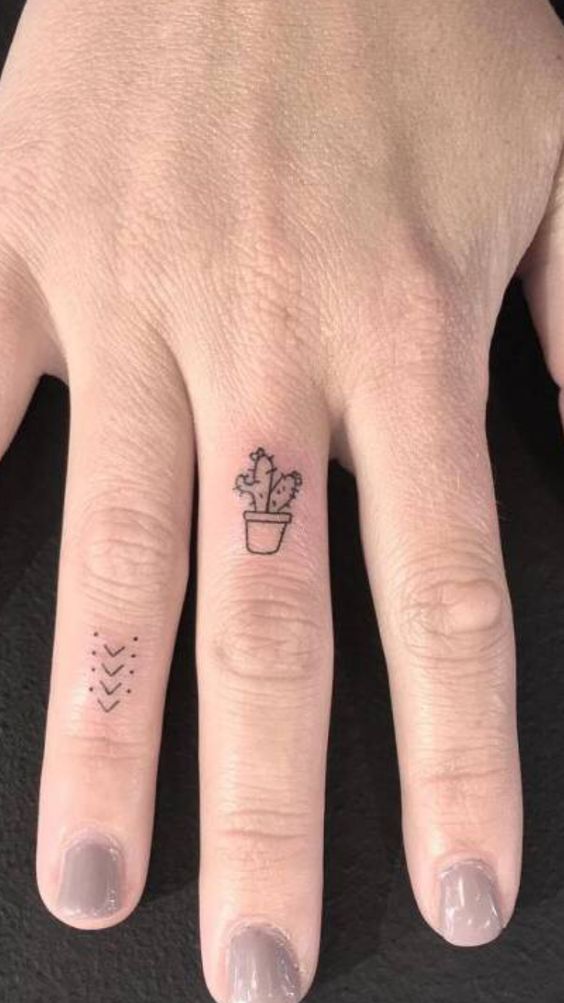 Hình xăm mini cây xương rồng trên ngón tay, phong cách blackwork, chi tiết rõ nét, độ phân giải HD.