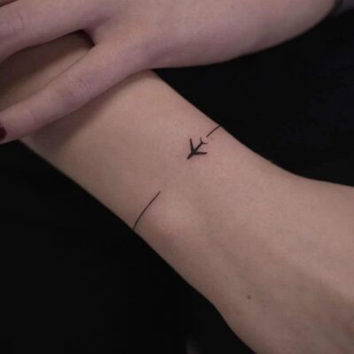 Hình xăm mini mũi tên trên cổ tay, phong cách blackwork, chi tiết đơn giản, ảnh độ phân giải HD.