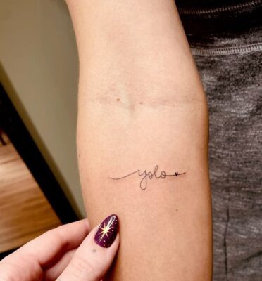 truyền cảm hứng sống hết mình Hình xăm chữ "yolo" trên tay, phong cách tối giản, chi tiết rõ nét, ảnh HD.