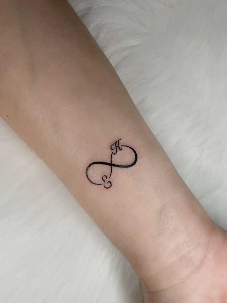 biểu tượng cho tình yêu bất diệt Hình xăm vô cực trên cổ tay, phong cách blackwork, chi tiết đơn giản, ảnh HD.