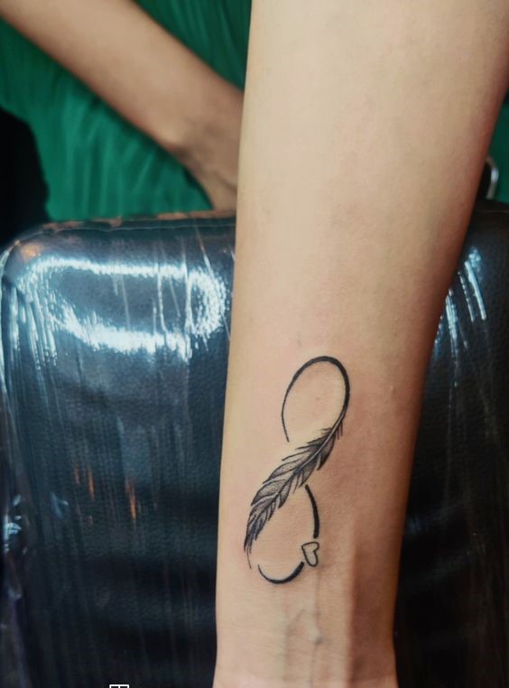 nét đẹp mong manh bền vững với thời gian Hình xăm lông vũ mini trên cẳng tay, phong cách blackwork, chi tiết rõ nét, độ phân giải HD.